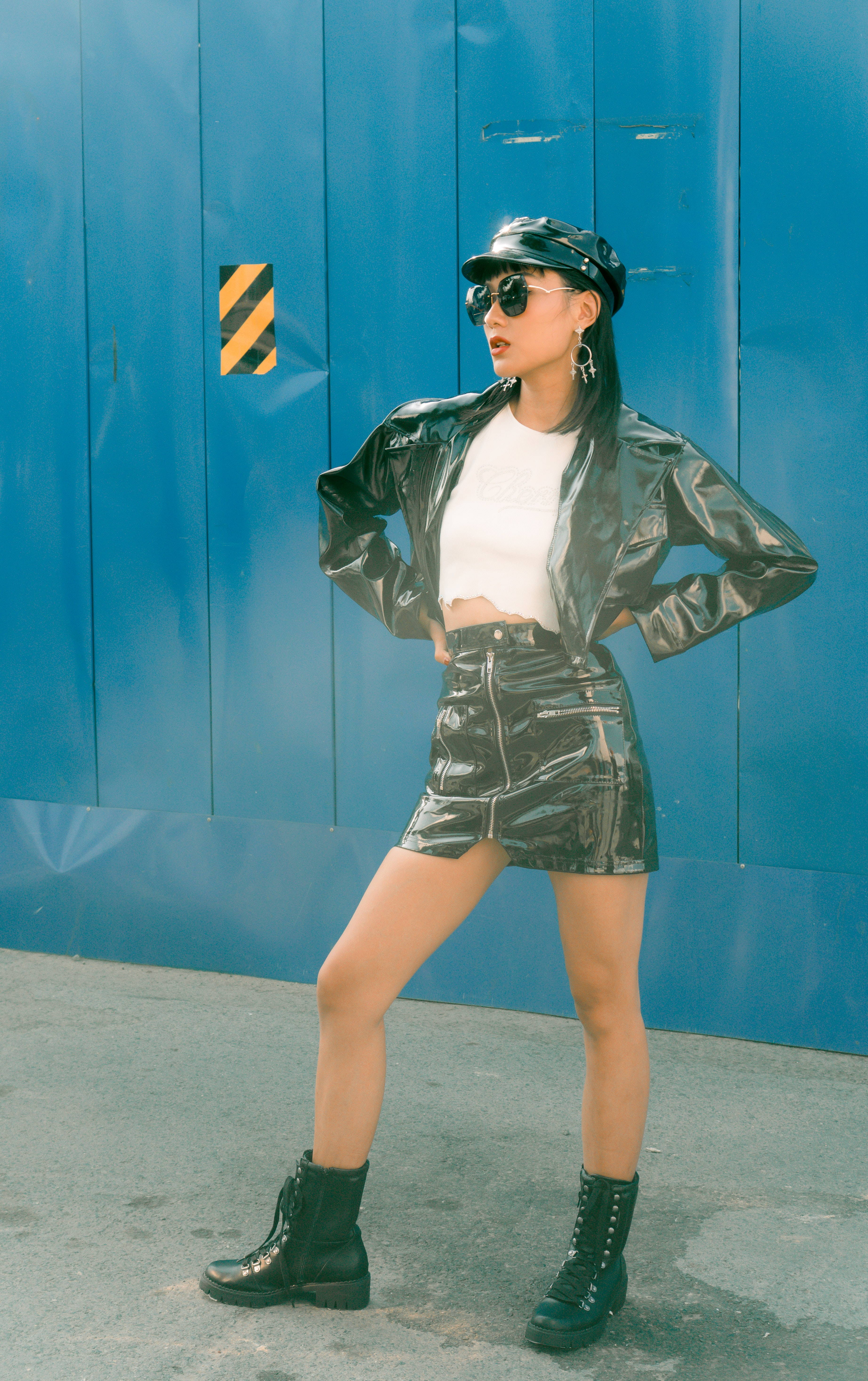 Image of a woman standing wearing a black pleater jacket.